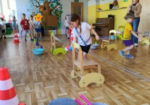 Dzieci w czasie zajęć ruchowych wykonują zadanie z piłeczkami.