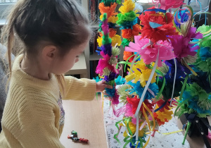 Dziecko przygląda się wykonanym na warsztatach palmom wielkanocnym.