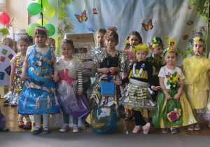 Dzieci pozują do wspólnego zdjęcia. Dzieci są ubrane w stroje konkursowe "Eko-strój".