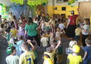 Dzieci i nauczyciele wspólnie tańczą na balu wiosny.