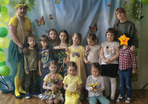 Dzieci i nauczyciele pozują do zdjęcia grupowego na balu wiosny. Grupa 3
