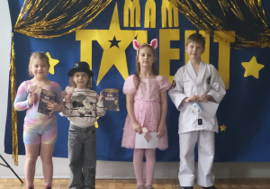 Dzieci z grupy 5 pozują do zdjęcia po występie. Zaprezentowały: gimnastykę artystyczną, wiersze i pokaz taekwondo.