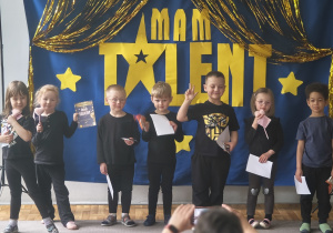 Dzieci z grupy 2 pozują do zdjęcia po występie. Zaprezentowały: inscenizację wiersza, taniec z rekwizytami.