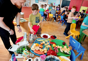 Dzieci i nauczyciel w czasie przygotowywania koktajli warzywno-owocowe. Grupa 4. Ujęcie 4