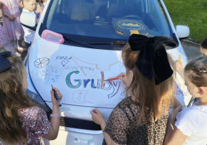 Dyskoteka starszaków - dzieci ozdabiają auto firmowe Grubego Benka. Ujęcie 2