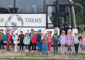 Zabawy i zajęcia w Michałówce. Dzieci pozują do wspólnego zdjęcia na tle autokaru. Grupa 2